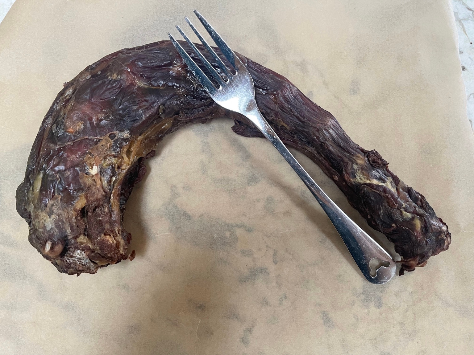 Dried turkey neck pictured beside a fork